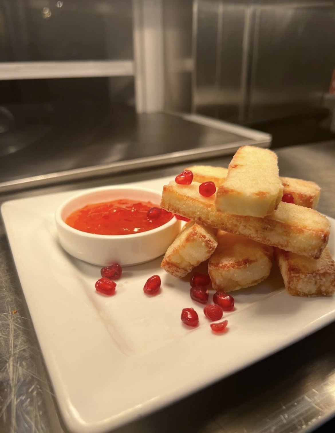 Golden halloumi fries with sauce and pomegranate